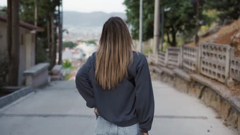 female tourist with mobile photo camera walking through old town streets