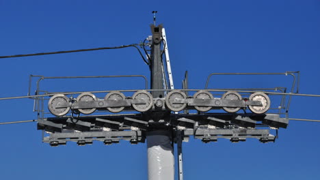 close up time lapse of a ski lift pole with the wheels going around in the alps