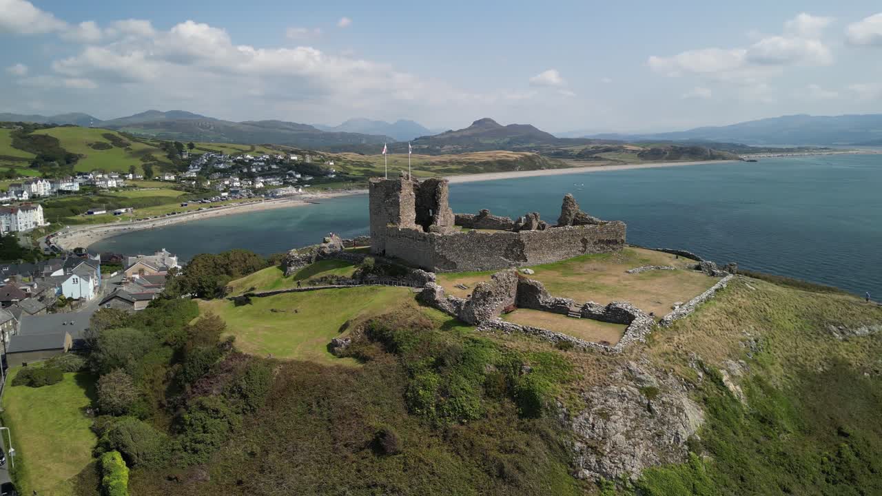 Stunning Criccieth Castle on a lovely summer afternoon - panoramic aerial drone clockwise rotate - North Wales, UK