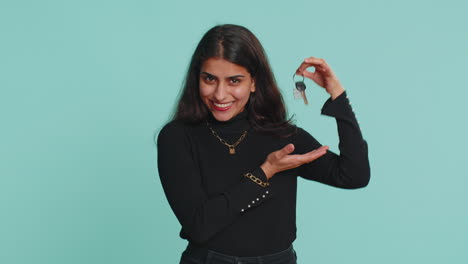 indian woman real estate agent showing keys of new home house apartment, buying renting property