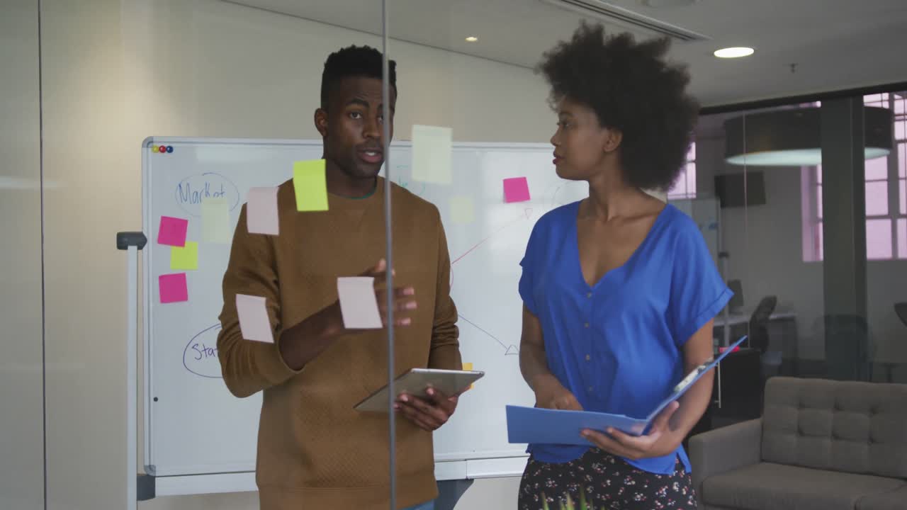 African american male and female business colleagues brainstorming in meeting room