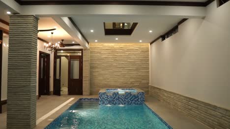 view of indoor swimming pool in luxury home with blue white tiling