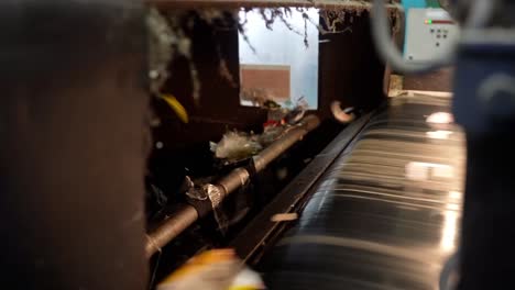 waste sorting conveyor, mixed garbage stream, automated processing line, various materials moving. initial stage of waste recycling.