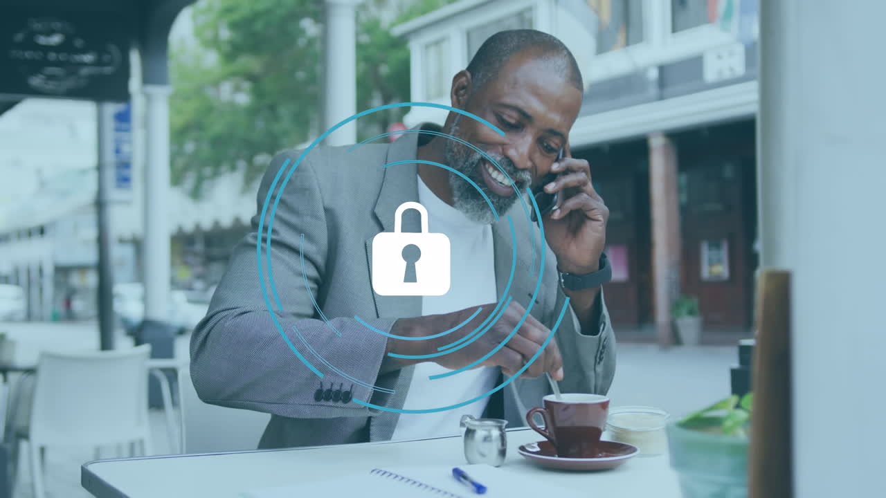 Animation of padlock with circles over african american man talking on cellphone and mixing coffee
