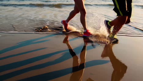 people running on a beach at the water's edge