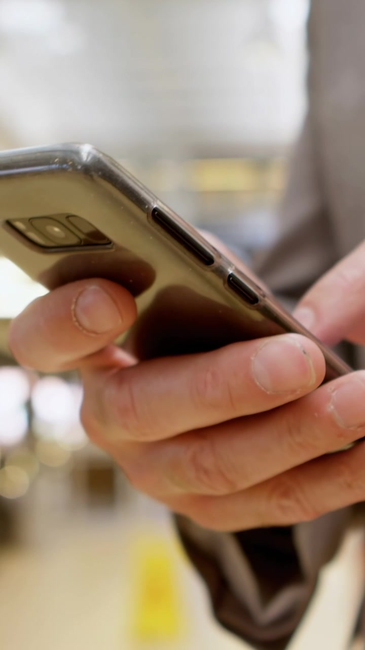 Video verticale: Uomo che tocca il telefono in un centro commerciale, facendo apparire bolle che si accumulano e potenziano il marketing.
