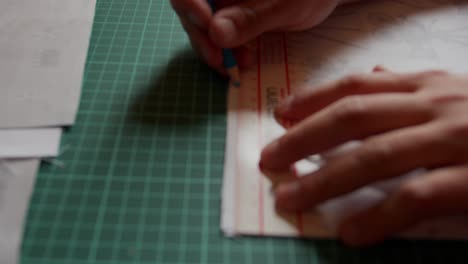 marking on fabric with ruler to measure. slow motion. backward motion.