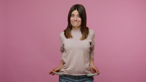 pobre estudiante morena preocupada que parece molesta y muestra los bolsillos vacíos de adentro hacia afuera, gestando que no tiene dinero.