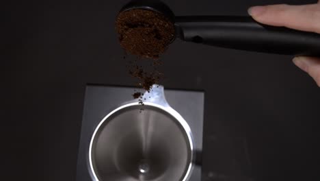 coffee falling out of a coffee spoon into a pour over coffee maker in super slow motion