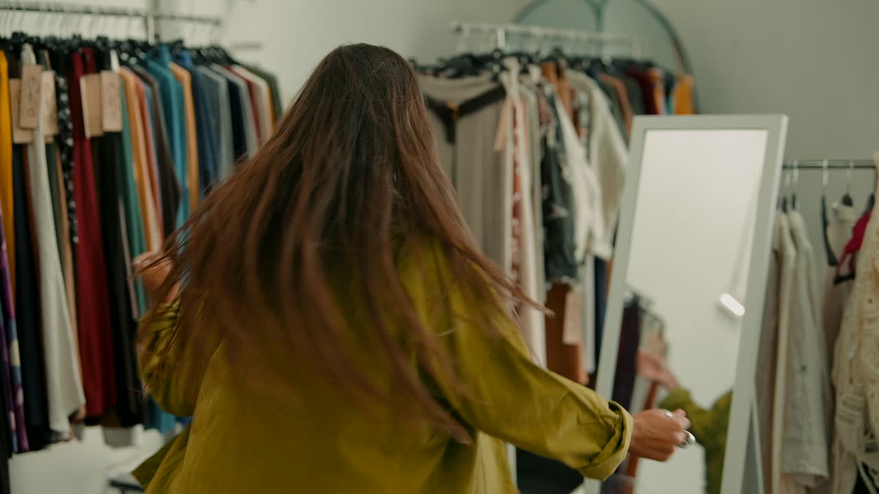 A woman standing near a rack of clothing