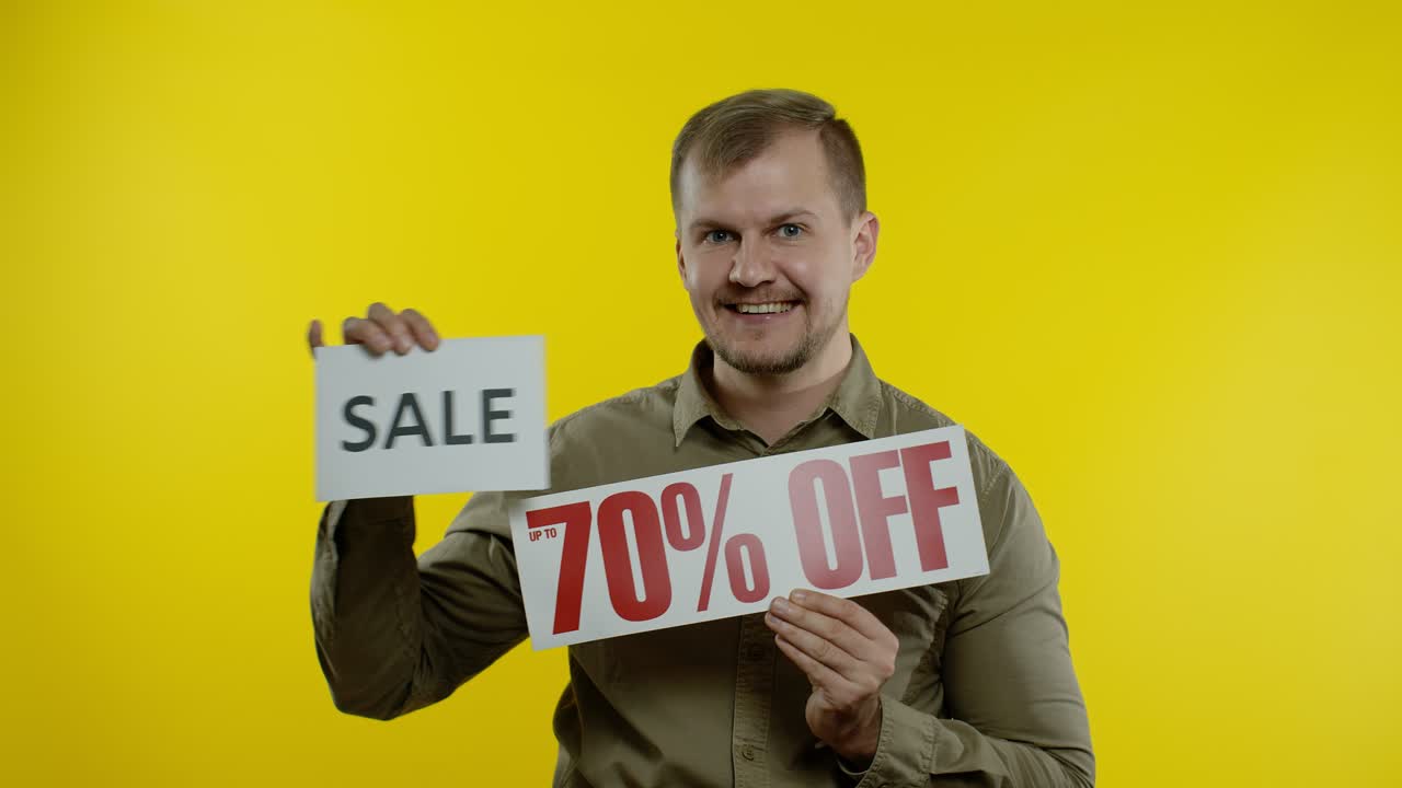 hombre alegre mostrando palabra de venta y mostrando hasta un 70 por ciento de descuento en la inscripción. concepto de viernes negro