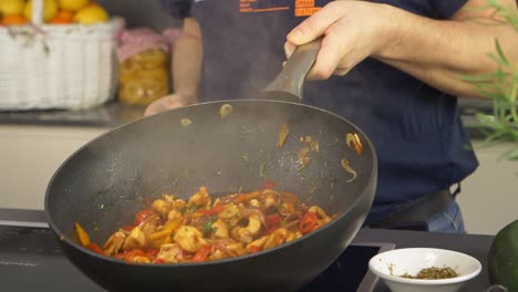 un cocinero arrojando ingredientes en la sartén con algunos trucos profesionales en cámara lenta