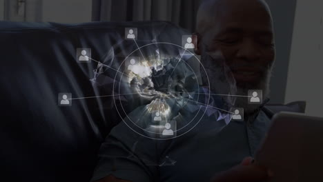 animation of networks of connections with icons over man using tablet