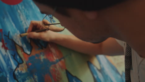 close-up of artist detailing abstract painting with brush