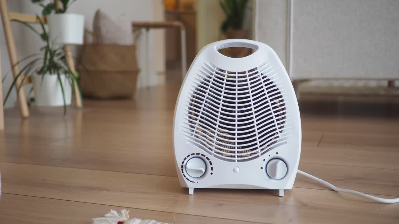 White Electric Fan Heater on Wooden Floor in a Room