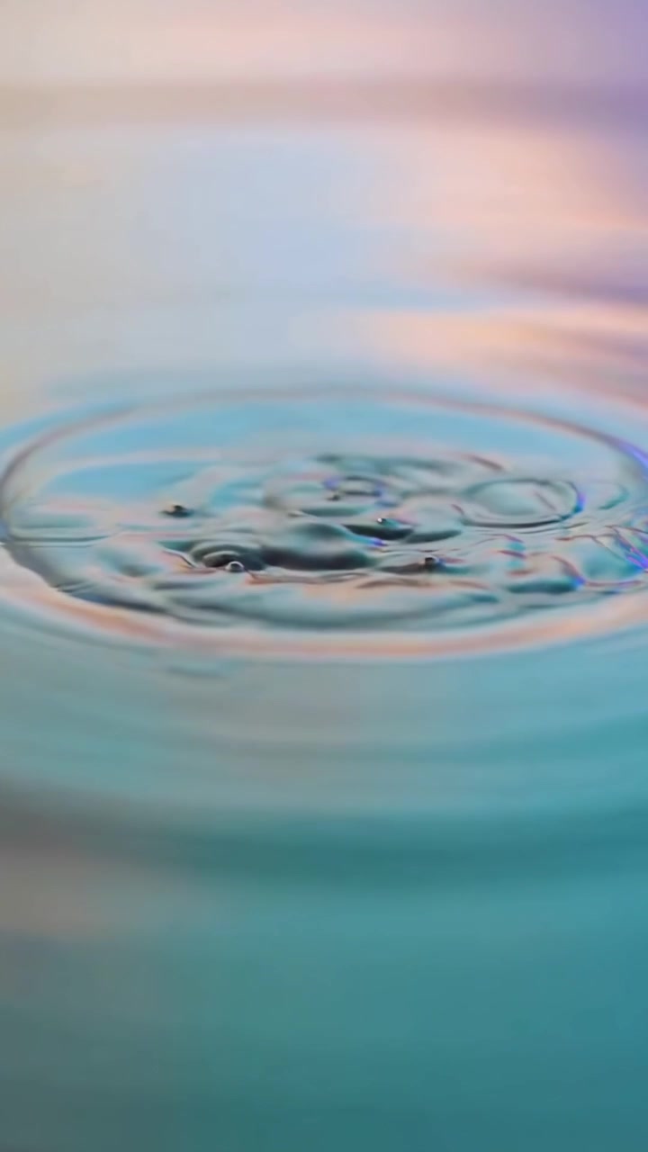 Slowmotion vanddråbe plasker på farverig overflade