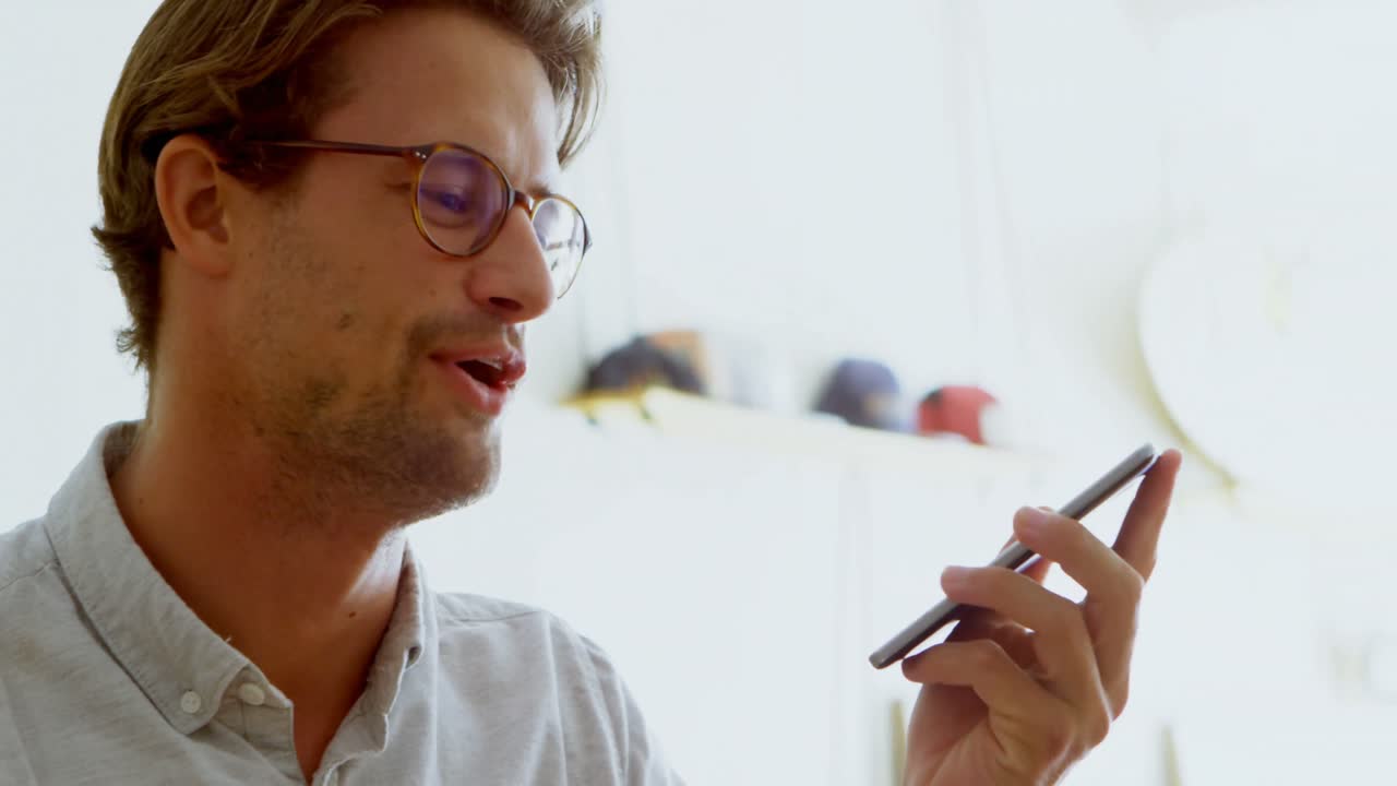 hombre hablando por teléfono móvil en la sala de estar 4k