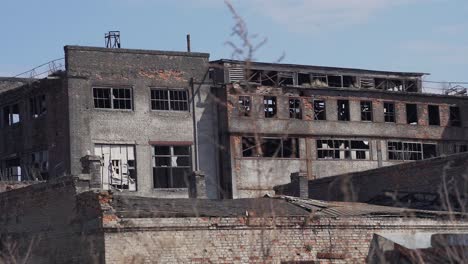 broken destroyed concrete and brick buildings of an old abandoned factory with broken windows. industrial buildings in ukraine