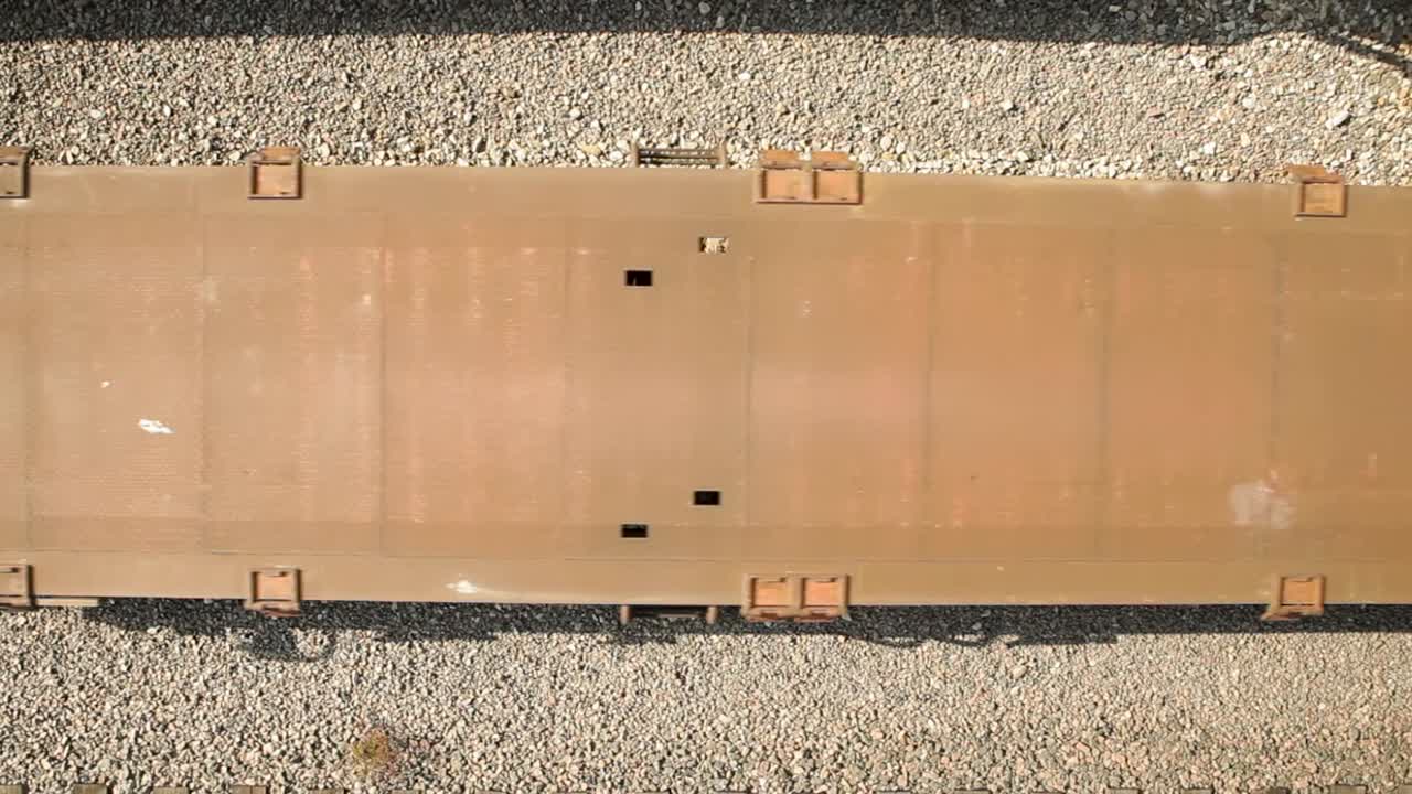 낮에는 철도와 화물 요소를 상세히 보여주는 트랙에서 움직이는 화물 열차의 위에서 아래로 볼 수 있습니다.