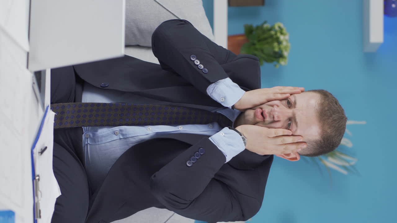 Vídeo vertical de homem em home office vê seu fracasso no laptop