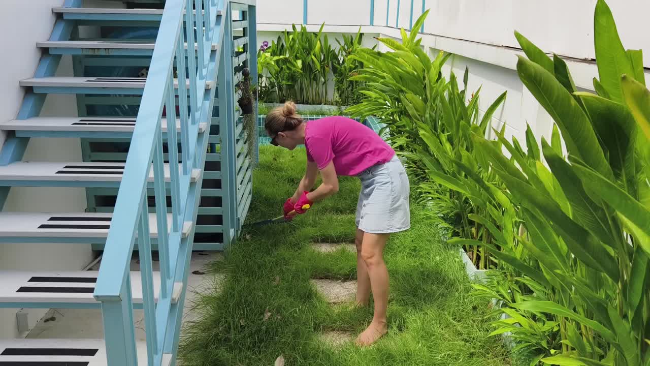 mujer rastrillando hojas en el jardín del patio trasero