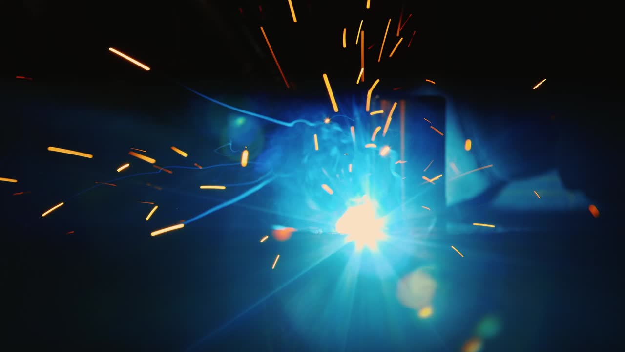 보호용 헬멧과 옷을 입은 용접공이 스파크가 날 때 용접합니다 3