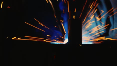 a welder in a protective helmet and clothes welds as sparks fly 3