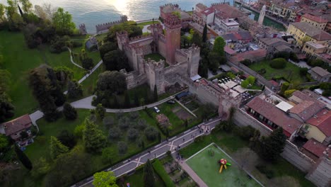 vista aérea inclinada que revela un castillo medieval en el pueblo italiano del lago garda
