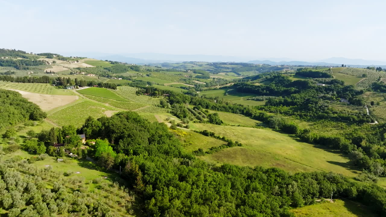 Drone rising over countryside fields and rural plantations in Tuscany, Italy