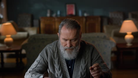 Grey-haired-man-reading-letter-luxury-room.-Senior-gentleman-sitting-table-home.