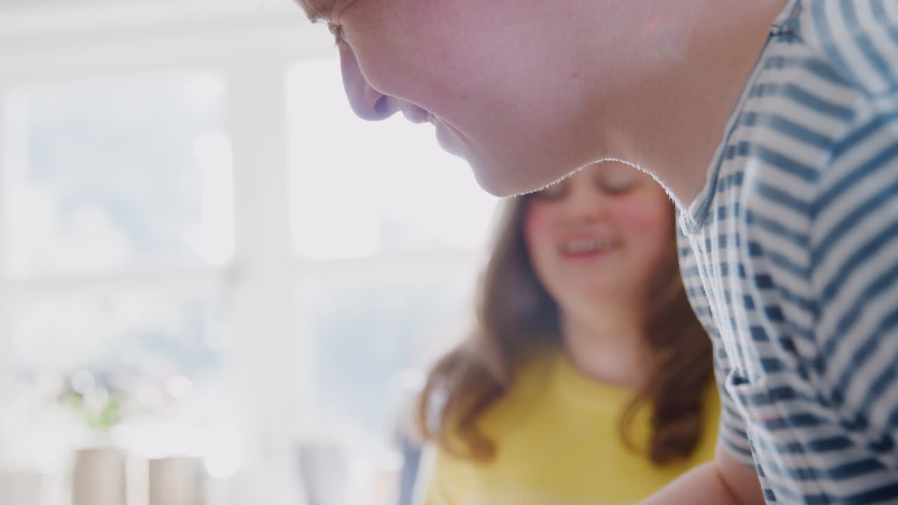pareja joven con síndrome de down midiendo ingredientes para hornear pastel en la cocina en casa