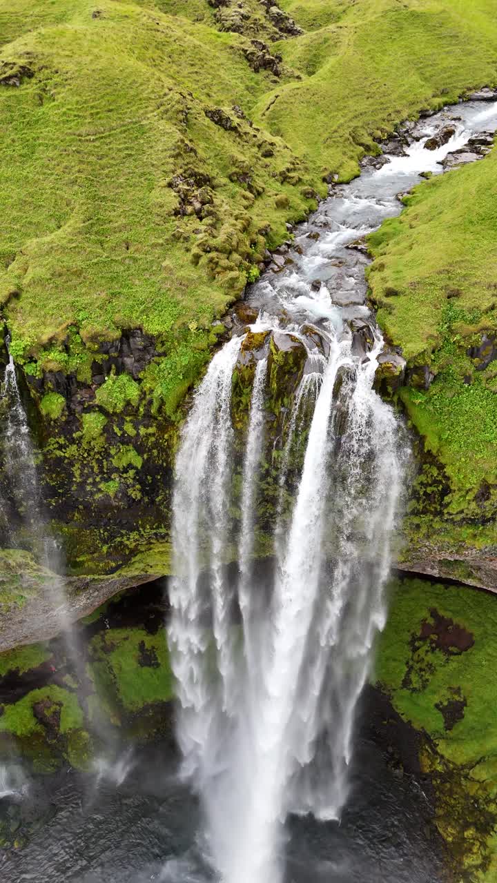 Close, slow motion vertical video of the majestic Seljalandsfoss waterfall, in Iceland.