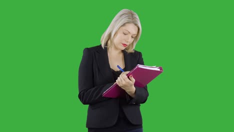 an attractive businesswoman is writing notes with a pen