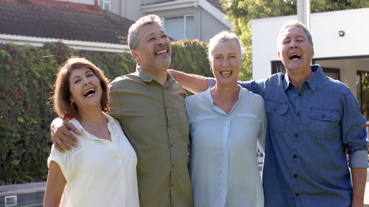 Smiling senior friends standing together outdoors, enjoying time and laughing