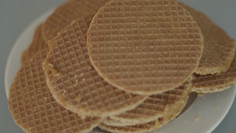 Top-down-dolly-of-pile-of-stroopwafels-on-white-plate---close