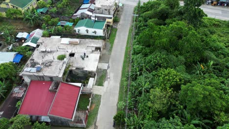 Vista-Aérea-De-Un-Tranquilo-Pueblo-Filipino-Subdesarrollado-Con-Exuberante-Vegetación,-Calles-Vacías-Y-Tejados-Deteriorados