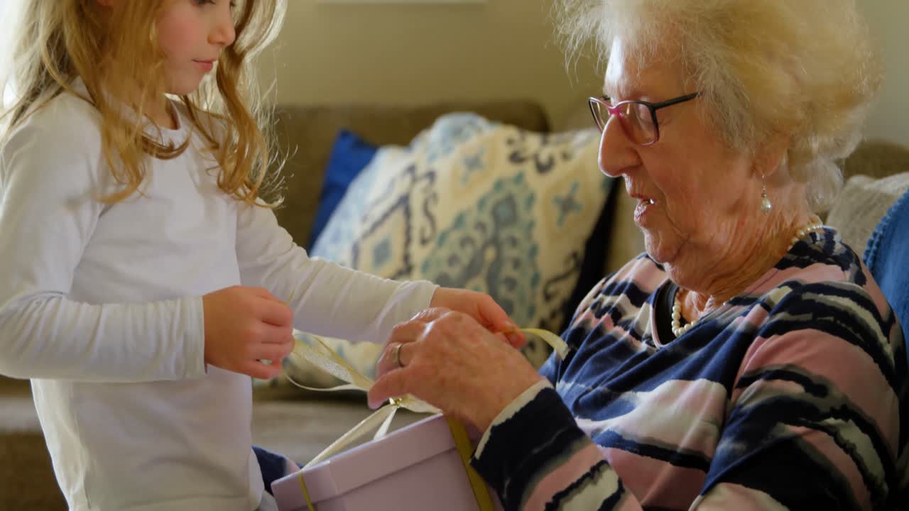 손녀 가 거실 4k 에서 할머니 에게 선물 을 주는 것