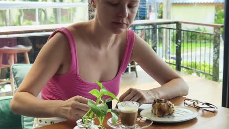 woman enjoying coffee and pastry in a cafe