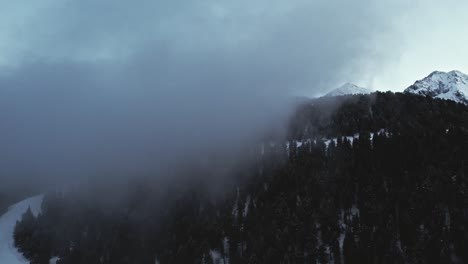 drone flying into cloud at a ski slope on snowy alpine mountain