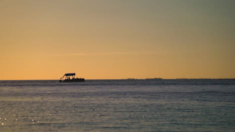 Barco-Pontón-En-Un-Crucero-Al-Atardecer-En-Los-Cayos-De-Florida,-Silueta-Con-Ave-Acuática