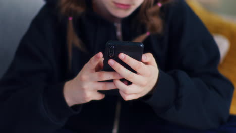 una adolescente usa un teléfono inteligente, un primer plano en las manos