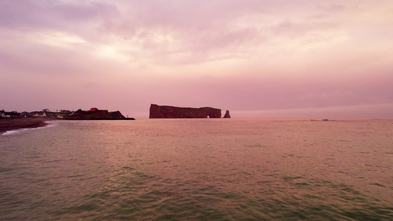 Vista de drone de la Roca Percé en Gaspésie durante un atardecer nublado.