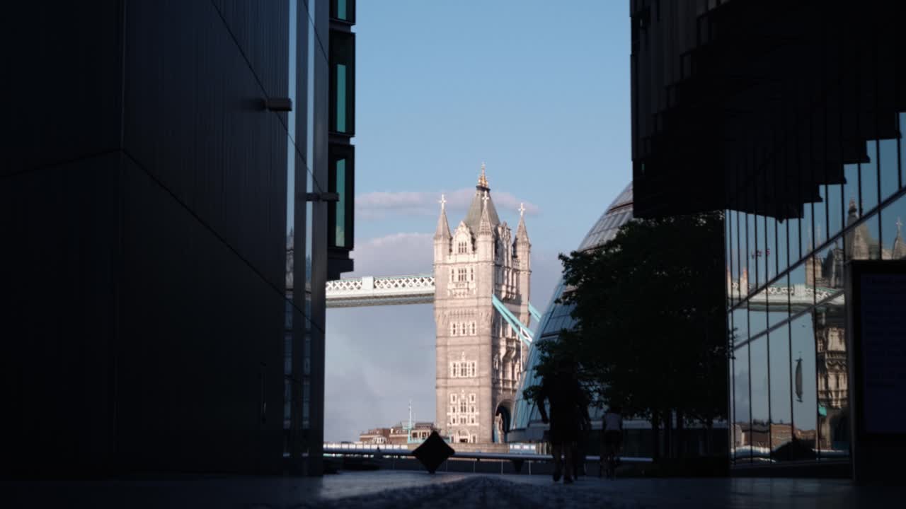Medium shot of Tower Bridge between the buildings.