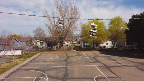 slow pan down from shoes trainers on wrapped around telephone phone wire down to small and empty distressed basketball court after covid-19 lockdowns end