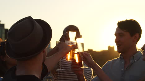 Freunde-Stoßen-Bei-Sonnenuntergang-Auf-Einem-Dach-An,-Aus-Nächster-Nähe