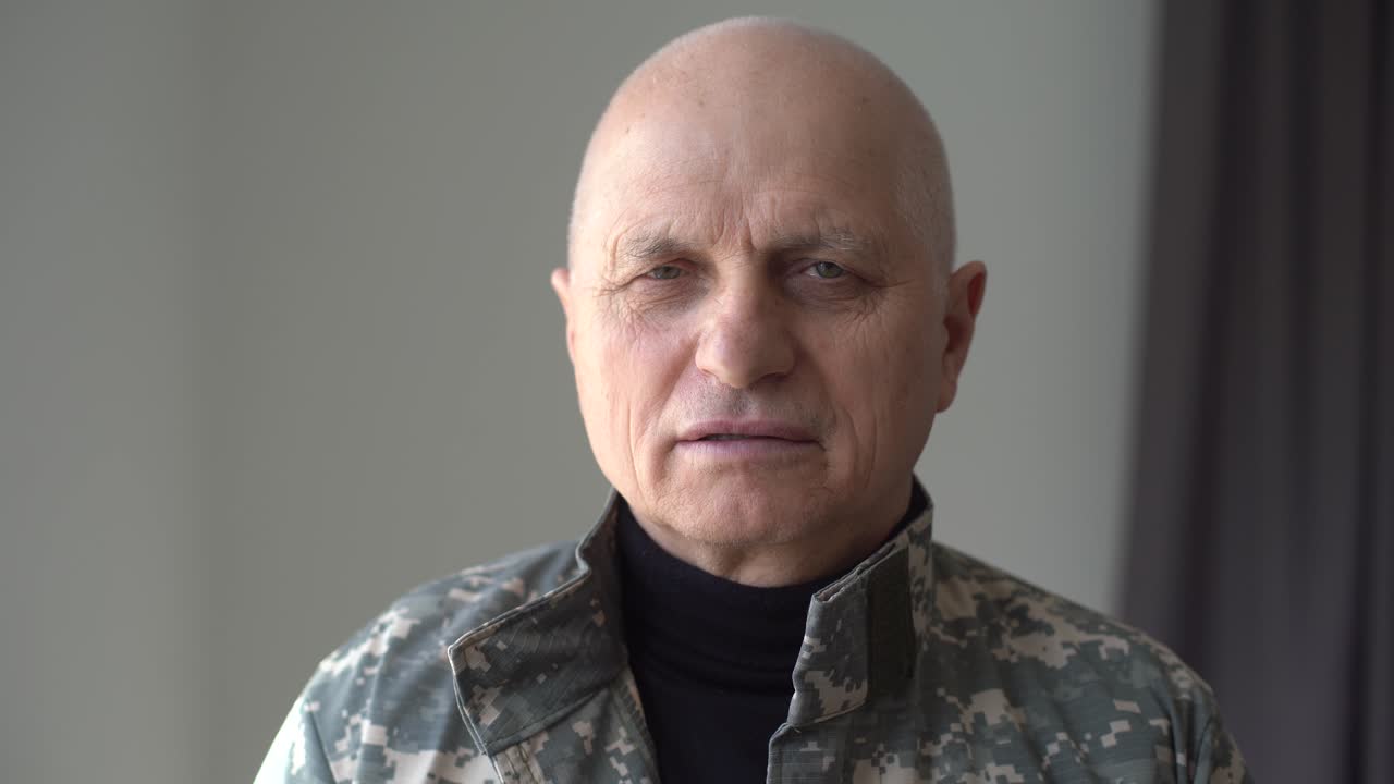 retrato de un piloto anciano o un militar o un conductor de tren con gorra con barba girando la cabeza y mirando a la cámara en la terminal del aeropuerto o la estación de tren. lente anamórfica, disparo de mano