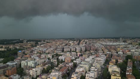 aerial drone tilt up shot over residential buildings with dark rain clouds hovering over the city of rome in italy on a stormy day
