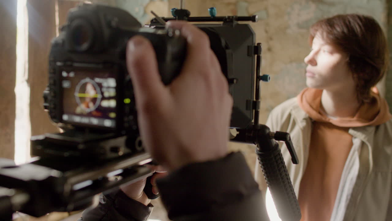 폐허가 된 건물 1에서 빨간 머리 소녀의 장면을 녹화하는 카메라맨의 클로즈업 뷰 1