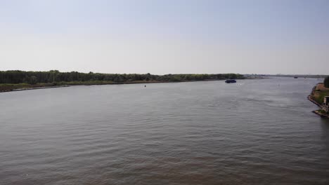 Speeding-Jetski-Passing-By-The-Sailing-Cargo-Ship-On-Waterways-During-Daytime