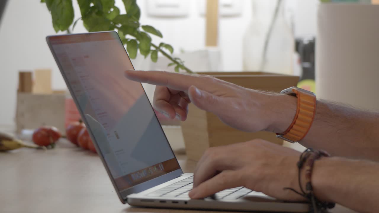 disparo en cámara lenta de las manos usando la computadora y apuntando a la pantalla de la computadora